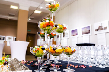 Pyramid of Glass Cups with Salad Display. An original display of a pyramid of glass cups filled with vibrant salad at a catering event.
