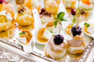 Elegant Gourmet Appetizer Selection. Elegant presentation of a gourmet appetizer selection, featuring bite-sized treats on a reflective surface.