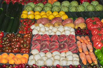 Colorful array of fresh vegetables and fruits neatly organized at a market stall ideal for nutrition and healthy recipes.