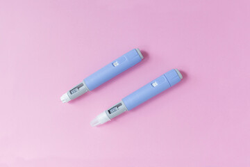 medical drug Ozempic injection lies on a pink background, top view. Medicine and weight loss, concept. injectors dosing pens for subcutaneous injection of antidiabetic medication or anti-obesity