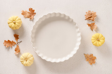 Autumn pumpkins, fall leaves, empty baking dish. Concept cook Pumpkin pie on white background. Top view. Copy space. Thanksgiving Day.