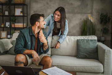 Obraz premium Adult girlfriend take care of her boyfriend while he work from home