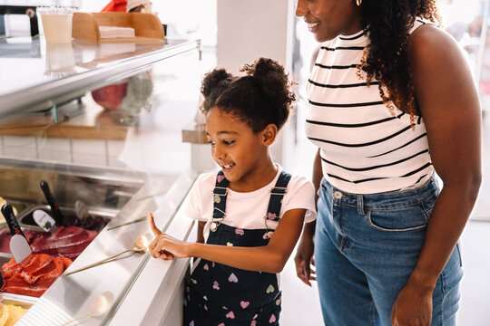 Mother and daughter enjoying dessert shopping at an ice cream shop