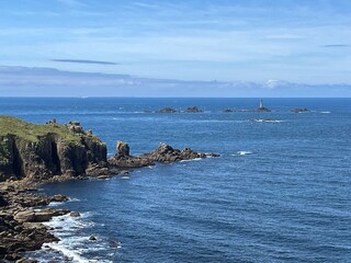 A beautiful cliff rises majestically above the ocean, its rugged rocks contrasting with the deep blue waters below. 