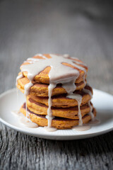 Decadent Stack of Pumpkin Spice Pancakes dripping with Sweet Syrup on a rustic gray wood background