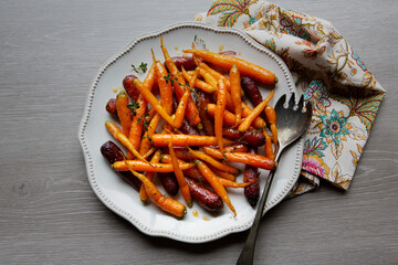 A large platter serving dish of glazed and roasted carrots with fresh thyme and honey