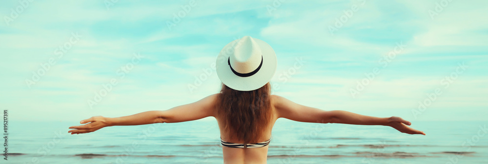 Wall mural summer vacation, beautiful happy woman in bikini swimsuit raising her hands up on the beach at sea