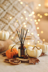 Cozy corner for home meditation and relaxation. Aroma diffuser, burning candles, pleasure and aromatherapy. Fall decor with pumpkins for apartment, house, indoors design. Thanksgiving decoration