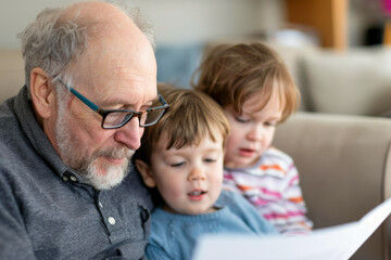 Grandfather Reading with Grandchildren on Couch