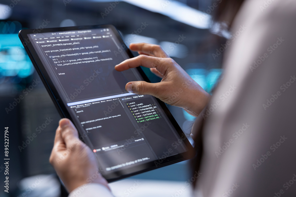 Poster admin in data center using diagnostic tools and system monitoring software on tablet device to ident