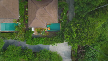 Female relaxes in swimming pool in exotic resort. The pool in jungle forest in private hotel villas. Tourist woman on yellow inflatable ring. Girl on summer vacation. Travel holiday in Thailand.