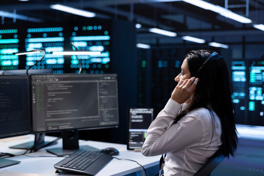 Admin in data center working on PC, providing technical support to customers, troubleshooting issues. High tech server hub worker carrying out operational technical interventions requested by clients