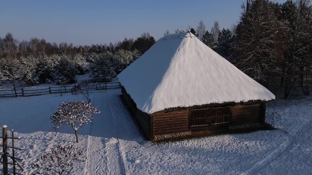 An outbuilding with a thatched roof. An old wooden barn.