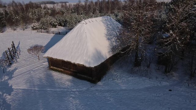 An outbuilding with a thatched roof. An old wooden barn.