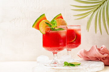 Fresh watermelon juice, made with fresh watermelon, lime, mint and ice cubes. Fruit Summer drink or cocktail in a white background.