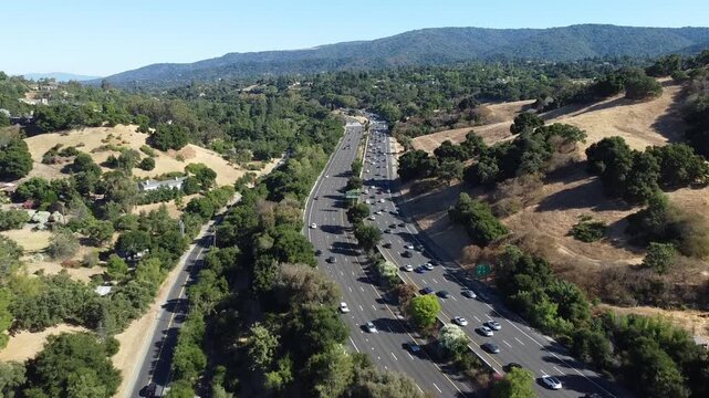 Aerial view of a busy highway 280 winding through a scenic landscape of hills and trees near Los Altos Hills, California