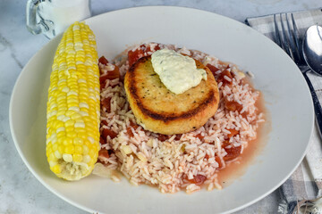 salmon top with tarter sauce  with rice and corn