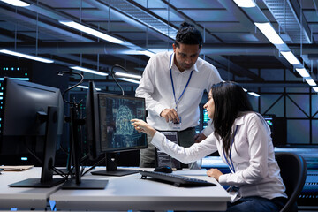 Team of technicians doing maintenance on server hub to optimize it for data processing requirements...