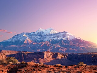 A stunning sunrise over the La Sal Mountains, casting a warm glow across the desert landscape of Moab. Snow-capped peaks contrast beautifully with the rugged terrain below.