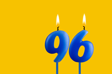 Blue birthday candle on yellow background - Number 96