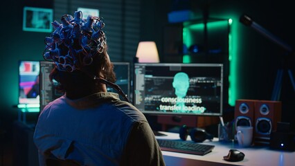 Engineer with EEG headset on programming brain transfer into computer virtual world, merging with...