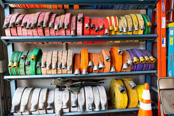 Fire hoses in rolls are stacked on racks at a fire station.