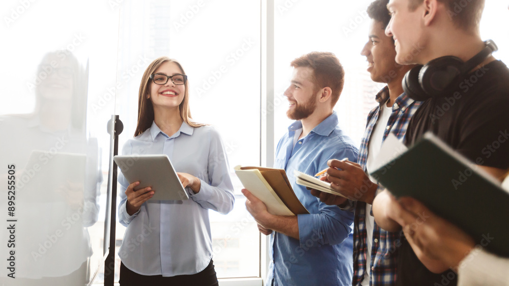 Aufkleber A diverse group of multiracial young people standing in front of a whiteboard, engaged in a discussion or presentation. Some are pointing at the board while others are taking notes