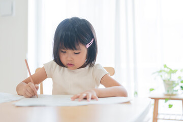 Naklejka premium 夏休みの宿題のプリントをやる小学生