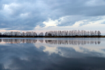 Obraz premium a beautiful reflection of the sky and clouds in the lake at sunset