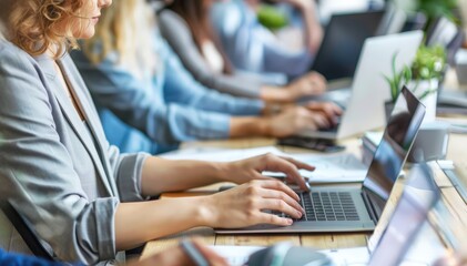 Focused on the Task: A close-up shot of a team of diverse professionals working diligently on laptops in a modern office setting, capturing the energy and focus of a dedicated workforce.  