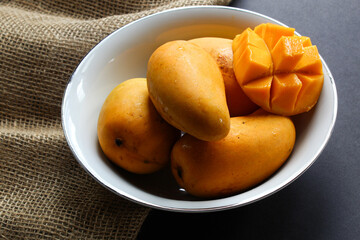 Bowl of mangoes on dark background