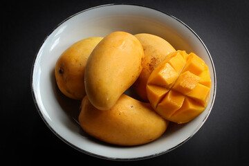 Bowl of mangoes on dark background