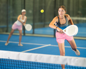 Portrait of cheerful girl paddle tennis player during friendly doubles couple match at court