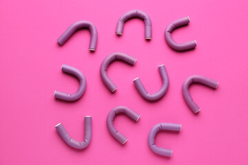 Hair curlers on pink background