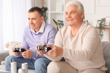Mature brothers playing video game at home