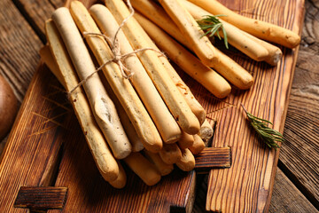 Board with tasty Italian Grissini on wooden background
