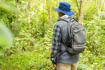 Male biologist from behind with a backpack, observing nature and enjoying the tranquility of the...