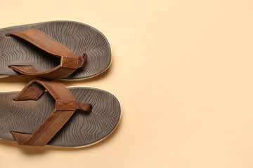 Brown flip-flops on beige background