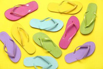 Colorful flip-flops on yellow background