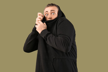 Scared mature man on green background