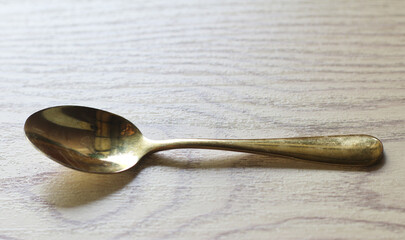 Golden spoon placed on wood