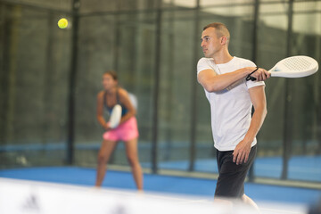 Padel game - girl with partners plays on the tennis court