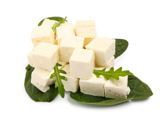 Tasty pieces of feta cheese with spinach and arugula on white background
