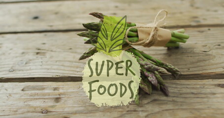 Super Foods text image over fresh asparagus bundle on rustic wooden table