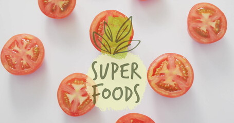 Super foods text image over sliced tomatoes on white background