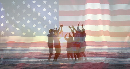 Image of american flag over diverse friends dancing on beach at sunset