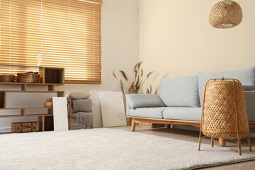 Obraz premium Cozy sofa and pictures on floor in living room