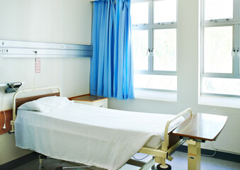 Hospital, healthcare and bed in empty room for healing and consulting for recovery or support. Curtains, wellness and furniture in clinic for service, emergency and rehabilitation for sick patient