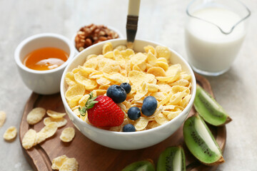 Wooden tray, bowl with cornflakes and berries on grunge background, closeup