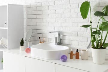 Sink with hair scalp massagers and bath accessories on drawers in room